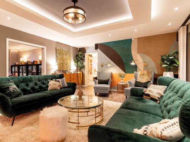 Kundenhaus SETROS von Kampa Wohnbereich mit grünen Sofas und toller Wandgestaltung