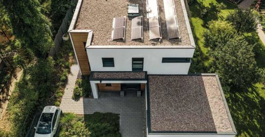 Weberhaus mit Flachdach und Photovoltaikanlage darauf