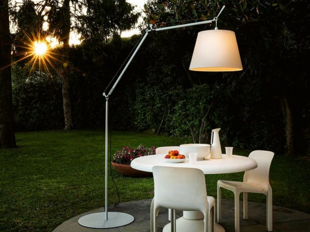 Gartenbeleuchtung Ideen für die kleine Terrasse mit einer Stehlampe von Artemide mit beidem waschbaren Schirm über einem runden weißen Esstisch