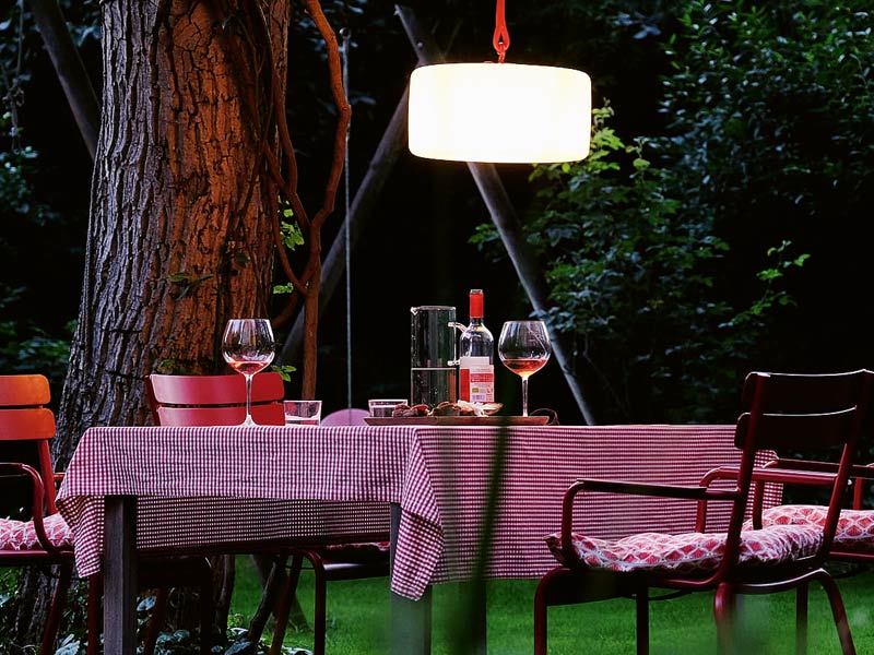 Ideen Gartenbeleuchtung für stimmungsvolles Licht über der gedeckten Tafel mit einer Swinger Lampe von Fatboy