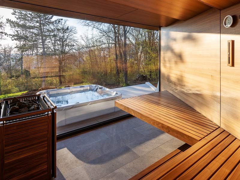 Sauna mit Whirlpool davor von KLAFS-Arnstein, Sauna mit riesigem Panoramafenster und freiem Blick in die Natur