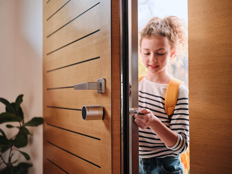 Mädchen öffnet Haustür mit Schlüssel