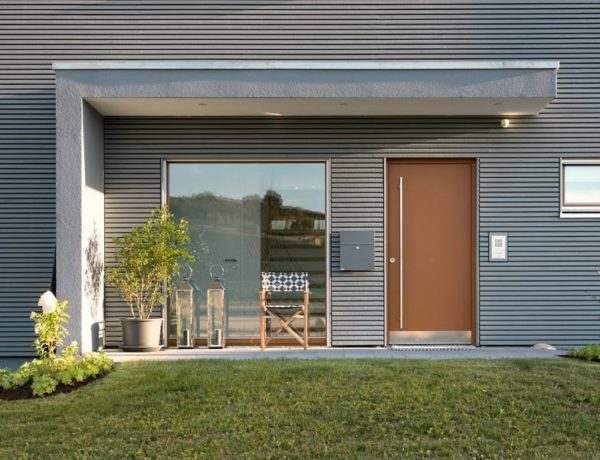 L-förmiges Vordach an dekorativem Hauseingang mit bronzefarbener Haustür