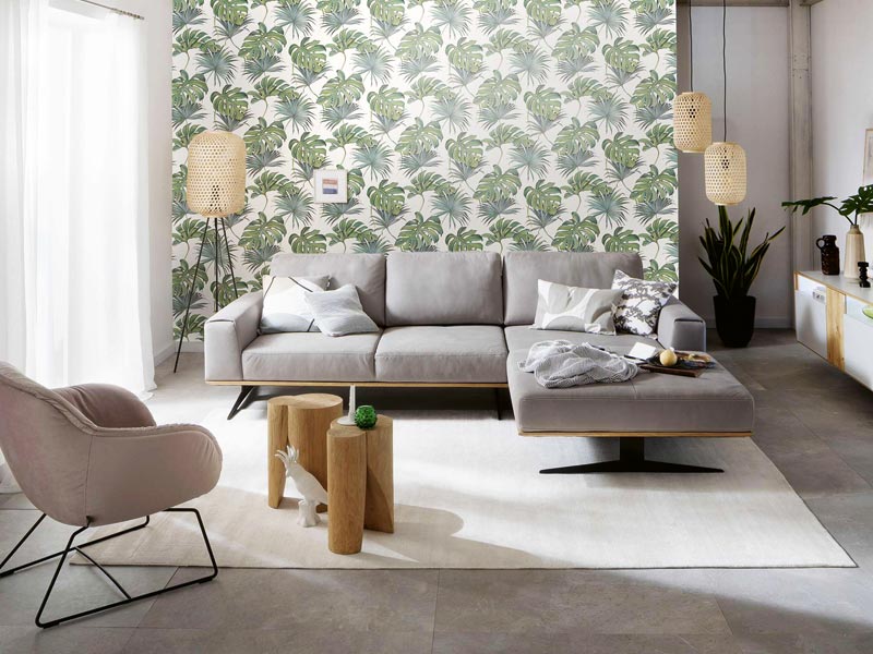 Vliestapete mit grünen Blättern im Wohnbereich hinter dem Sofa für die moderne Wandgestaltung