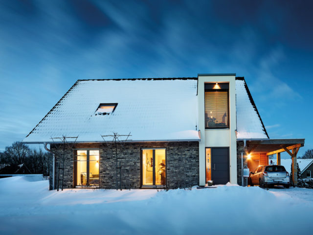 Gussek Haus Austum Aussenansicht am Abend mit Carport im Schnee