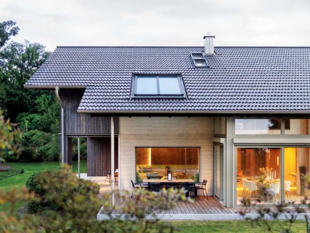 Sonnleitner Musterhaus Starnberg Aussenansicht auf die extra überdachte Terrasse am Erker mit Esstisch