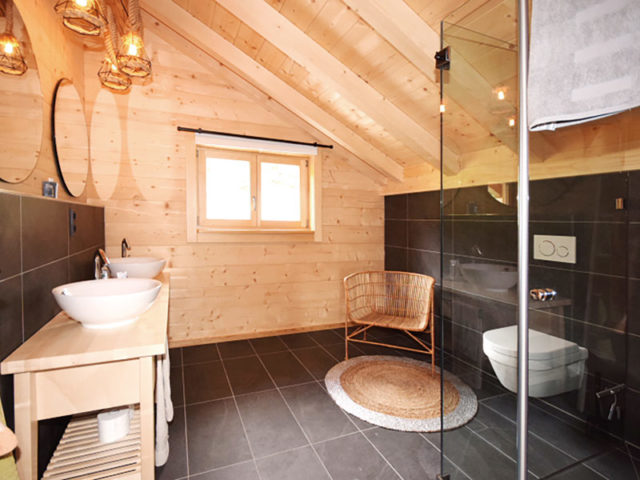 Bioholzhaus Mark individuelle Planung Bad mit dunklen Fliesen, Doppelwaschtisch und Dusche