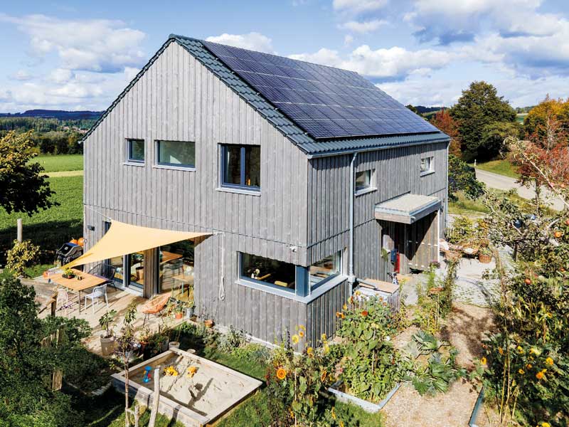 Kundenhaus Schmuck von Schwörerhaus - Aussenansicht mit PV-Anlage auf dem Dach und Sonnensegel über der Terrasse
