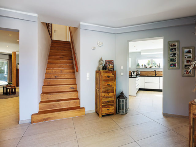 Architektenhaus Schöllnach von Wolf System Holztreppe ins Obergeschoss und Blick in die Küche