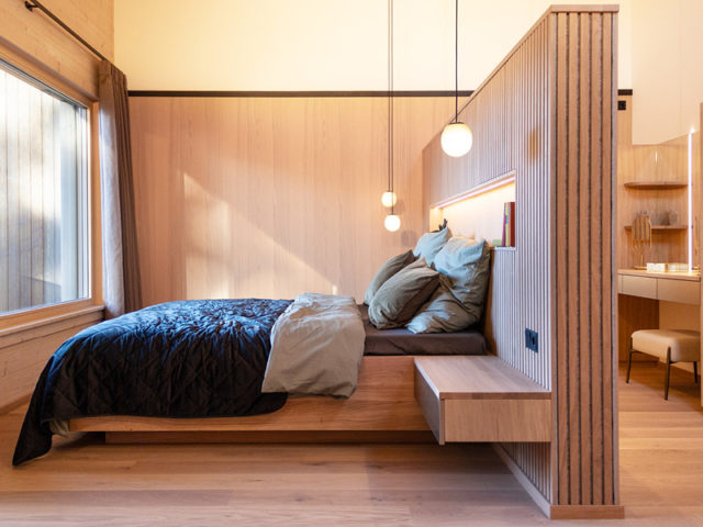 Musterhaus Starnberg von Sonnleitner Schlafzimmer mit eingebautem Doppelbett und Nachtkonsolen aus Holz