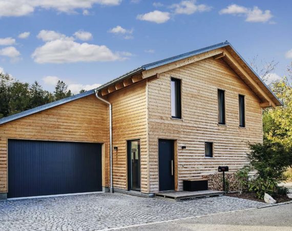 Haus Ullrich von Baufritz Eingang und Garage und komplett mit Holz verkleidete Fassade