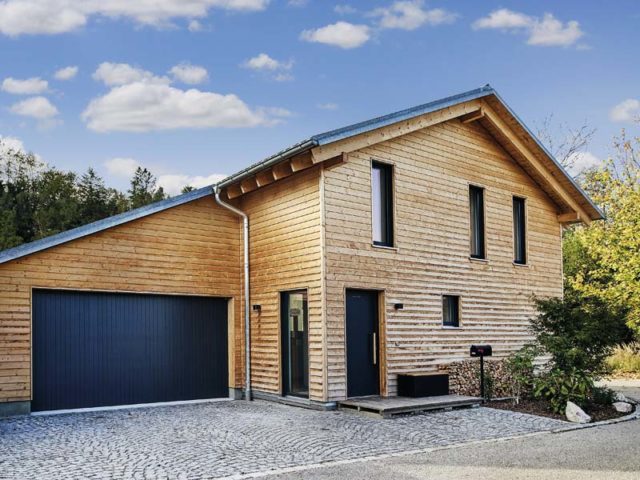 Haus Ullrich von Baufritz Eingang und Garage und komplett mit Holz verkleidete Fassade