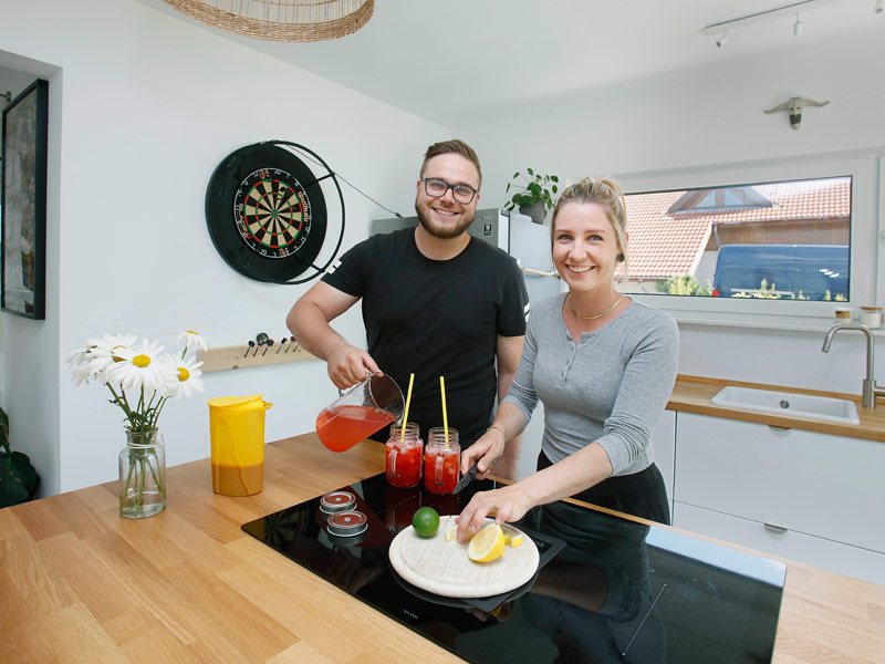 Ein Paar steht in der Küche und bereitet Cocktails zu.