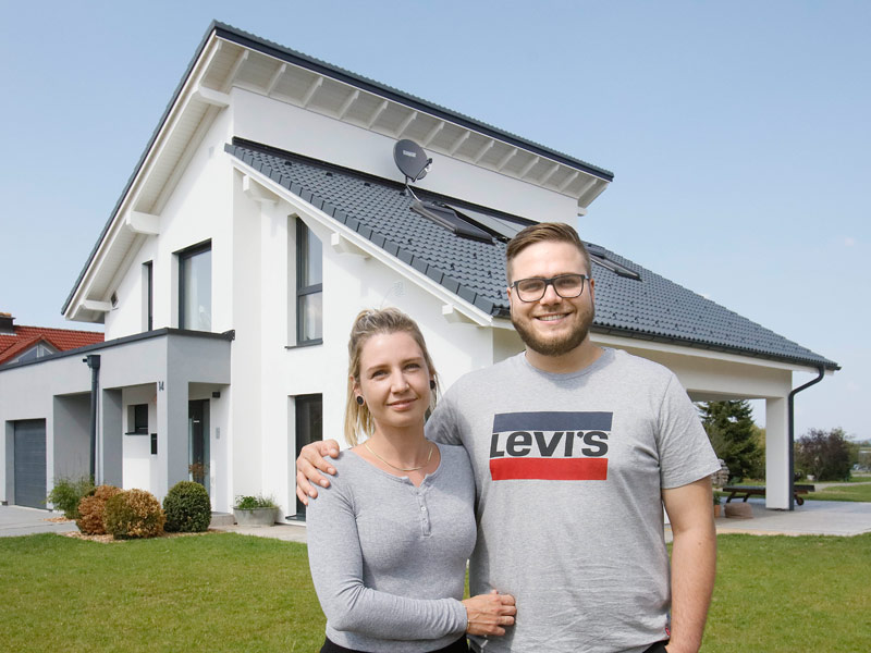 Bauherrenpaar vor ihrem Traumhaus von Danwood mit versetzten Pultdächern