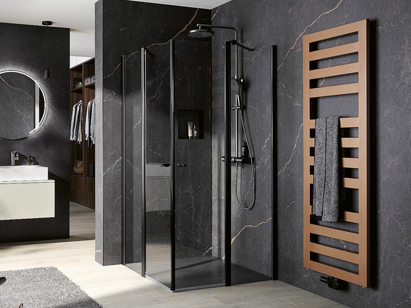 Edles Bad in Schwarz mit gläserner Dusche und kupferfarbenem Hnadtuchheizkörper daneben