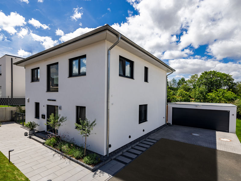 LUXHAUS Walmdach 169 Aussenansicht mit Eingang und großer Garage