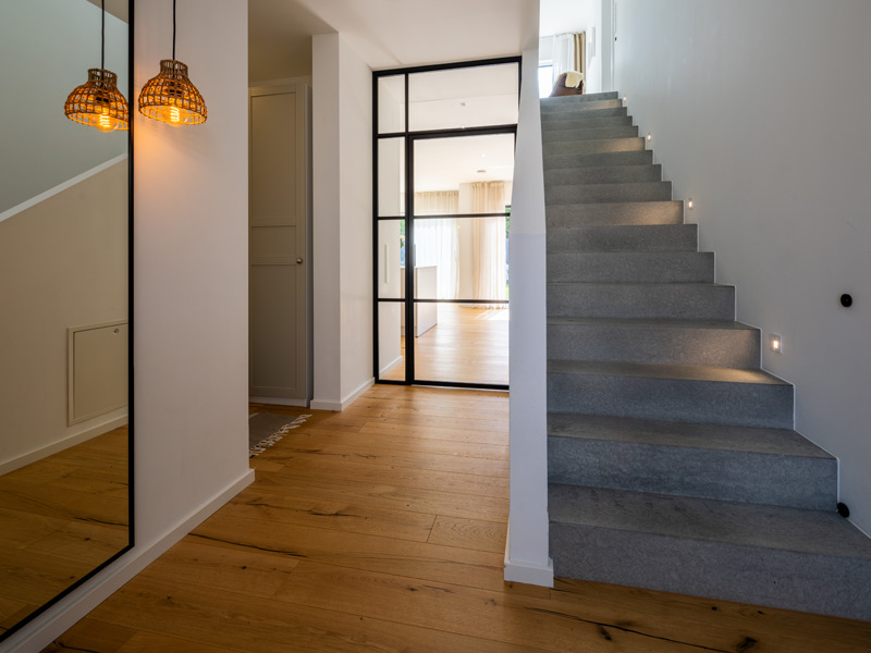 LUXHAUS Walmdach 169 Flur mit Betontreppe und Glastrennung im Industrial-Style