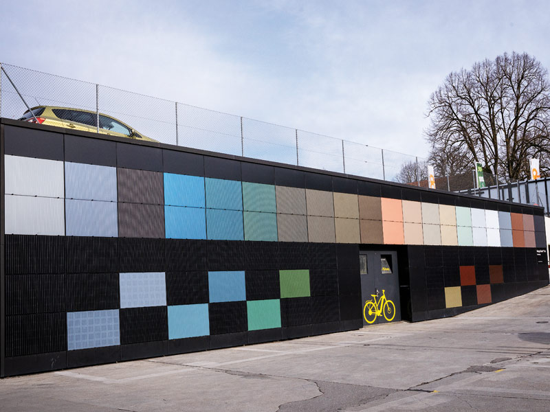 Eine Wand mit vielen verschiedenfarbigen Solarmodulen.
