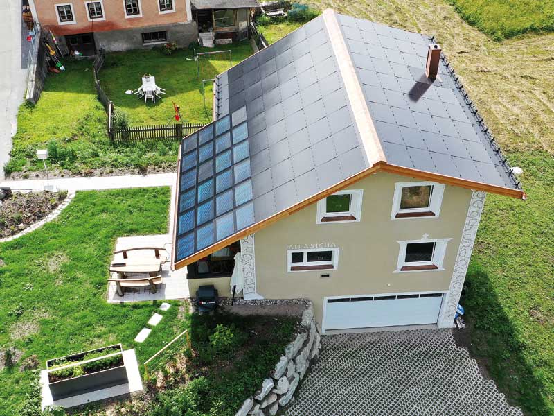 Moderne Dächer - Einfamilienhaus mit einem Dach aus Photovoltaikmodulen und Sollarkollektoren