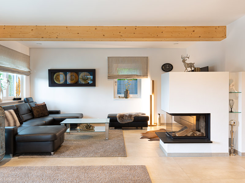 offener Wohnbereich mit großem Sofa und Kamin in einem Wohnhaus in Niederbayern von Wolf System