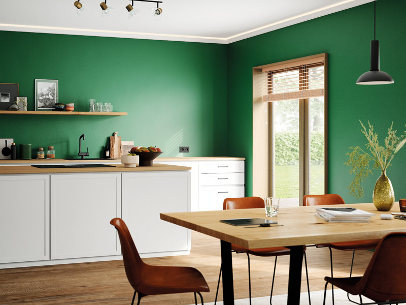 Küche mit weißen Fronten und Holzarbeitsplatte mit passendem Esstisch und alle Wände sind in einem satten Grün gestrichen. Küche nachhaltig einrichten auch dank Farbe.