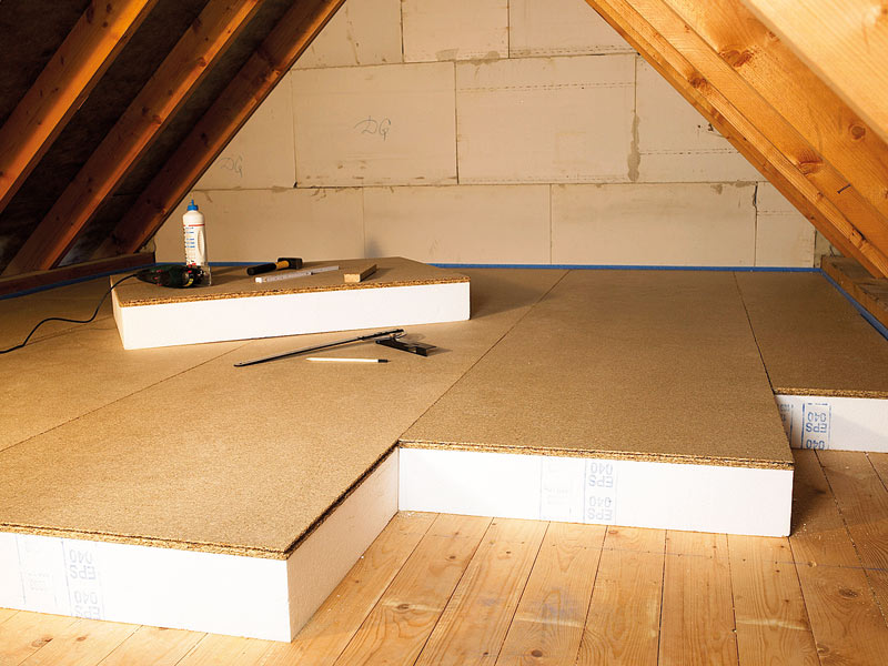 Auf einem Dachboden werden Styroporplatten verlegt zur Dämmung der Geschossdecke.