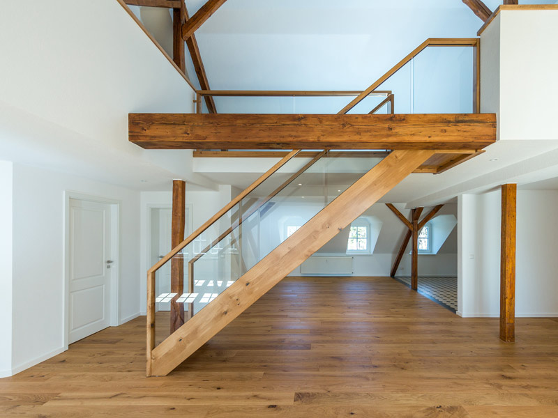 Holztreppe freistehend im Raum mit Glasgeländer