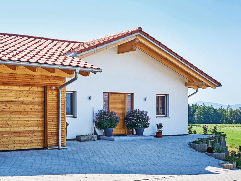 Sonnleitner Kunden Hechter Eingang mit zwei großen Blumenkübeln davor und die Hälfte der Garage ist links noch im Bild zu sehen.