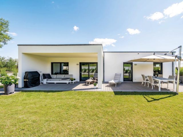 individuell geplanter Bungalow von Streif Gartenansicht mit teilüberdachter Terrasse und zwei Freisitzen