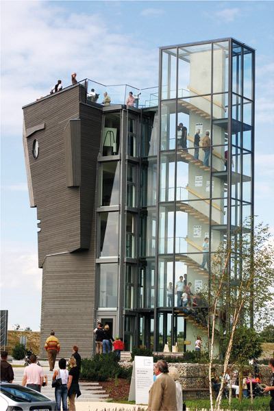 Besucher steigen auf den Aussichtsturm "Holzkopf" von Baufritz in der Erlebniswelt in Erkheim.