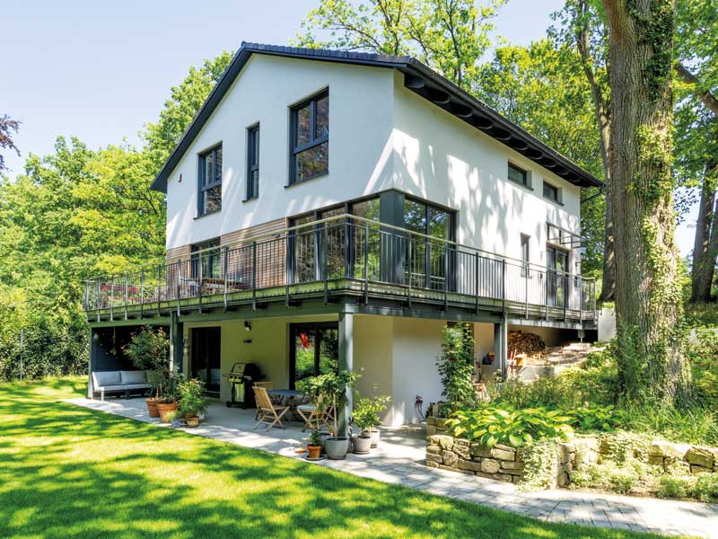 Bien-Zenker Kundenhaus Evers Aussenanischt mit Blick auf Terrasse und darüberliegendem Balkon mit Metallgeländer