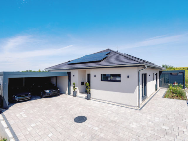 LUXHAUS Bungalow Walmdach 157 Aussenansicht Eingang und Doppel-Carport, sowie Photovoltaikanlage auf dem Dach ist zu sehen