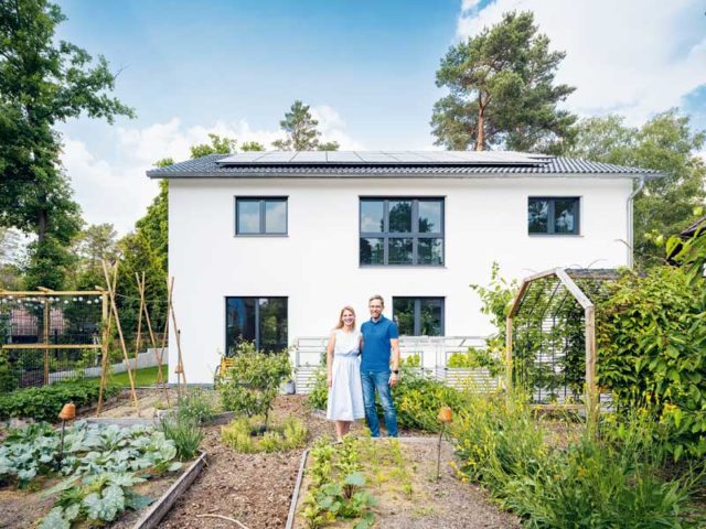 WeberHaus generation 5.5 Aussenansicht zum Gemüsegarten hin mit den Bauherren davor stehend