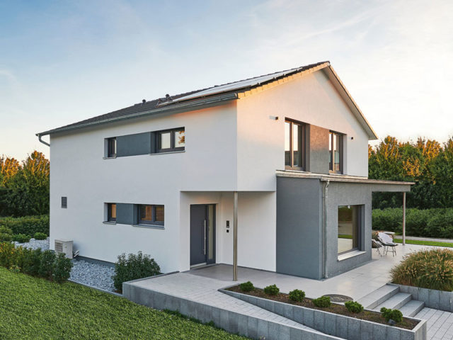 Aussenaufnahme Musterhaus Relax von Fertighaus Weiss weiß verputzt mit grauen Akzenten und klassischem Satteldach